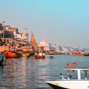 A scenic view of boats and a cruise on the Ganges River during a Varanasi boat ride, showcasing iconic ghats and temples.